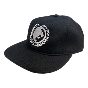 Renzo Gracie Latham's lion head design, embroidered on the front of a black AS Colour hat.  Cap features: lower profile, unstructured six-panel; adjustable fastener with metal clasp and tonal under-peak lining; mid-weight; flat peak; 50% wool/50% polyester fabric. One size fits all.