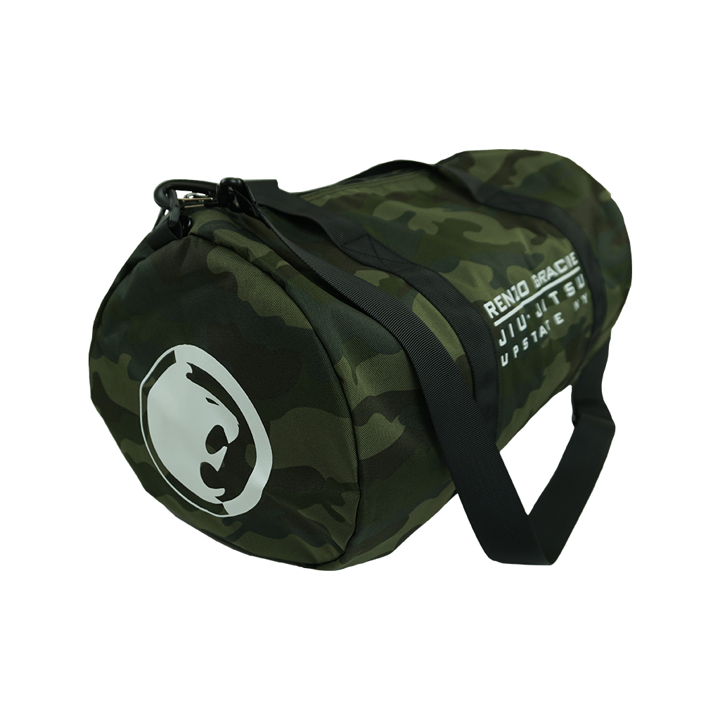 Renzo Gracie Latham's "Upstate Stack Logo" design, printed on the side of a forest camo Independent brand duffel bag.  Bag features include 100% polyester fabric, waterproof interior PVC coating, zipped mesh pocket (5.5” height, 8.25” width) on inside, carrying handles, and removable shoulder strap. Bag measures 20.5” x 10.5”.