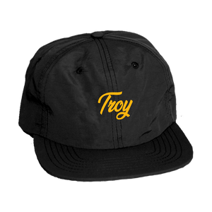 Keep your noggin dry in our custom-embroidered Troy simple script cap. Design is embroidered in gold on the front of a black nylon adjustable cap.  Only found at 518 Prints