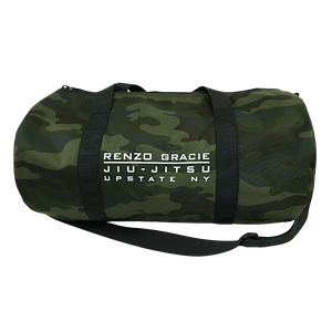 Renzo Gracie Latham's "Upstate Stack Logo" design, printed on the side of a forest camo Independent brand duffel bag.  Bag features include 100% polyester fabric, waterproof interior PVC coating, zipped mesh pocket (5.5” height, 8.25” width) on inside, carrying handles, and removable shoulder strap. Bag measures 20.5” x 10.5”.